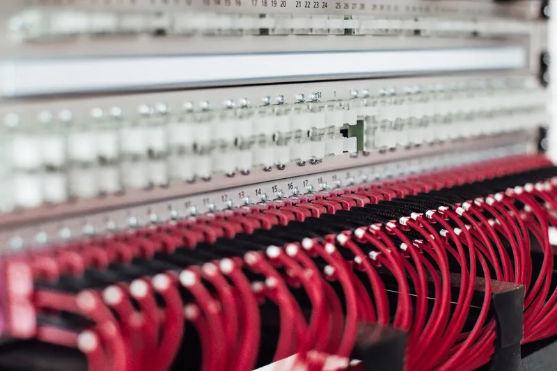 A server with a lot of ethernet wires connected. All of the wires are red and they are really well organized.